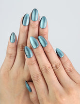 Model wearing Naillover Galaxy Gleam press on nails, shimmering blue galaxy design.